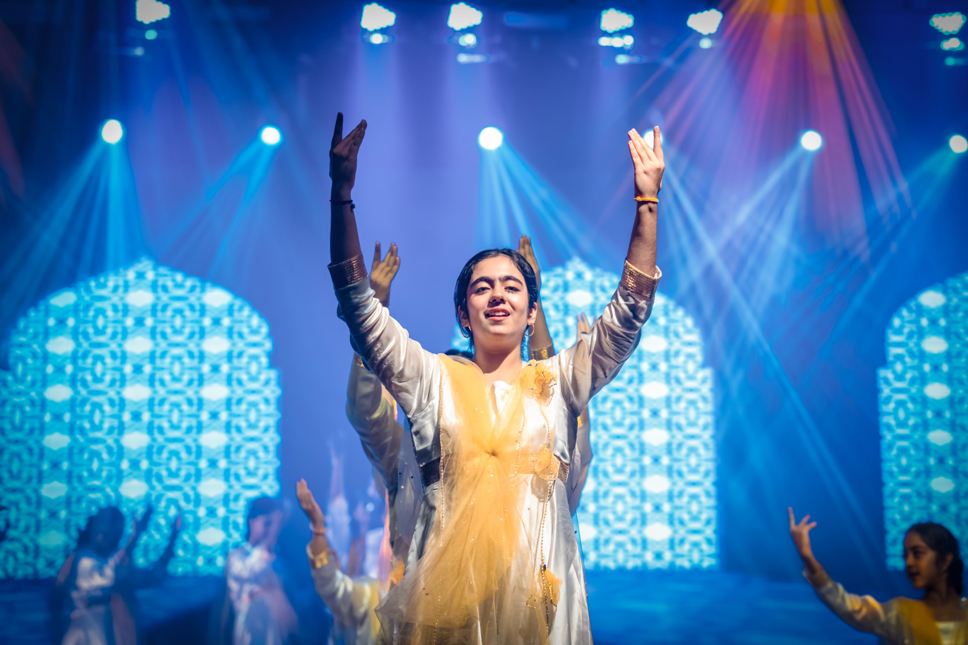 Student dancer performing under stage lights at a school Founder's Day celebration